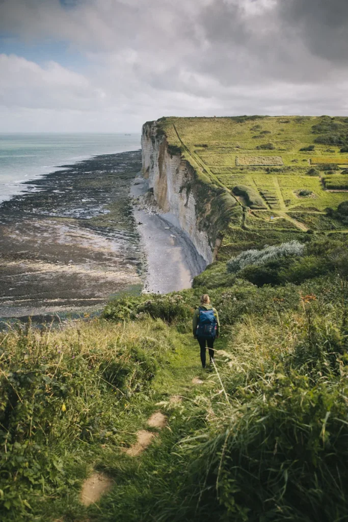 Femme en randonnée sur le GR21 entre Étretat et Yport, vue sur les falaises