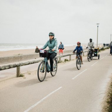 Une famille à vélo, sur la piste de la vélo-maritime, le long de la plage de Colleville-Montgomery