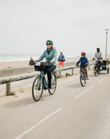 Une famille à vélo, sur la piste de la vélo-maritime, le long de la plage de Colleville-Montgomery