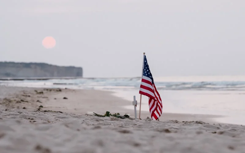 Drapeau américain sur la plage d'Omaha Beach au soleil couchant