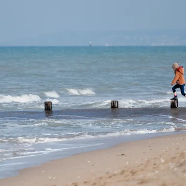 Enfant jouant sur une plage de Cabourg en hiver