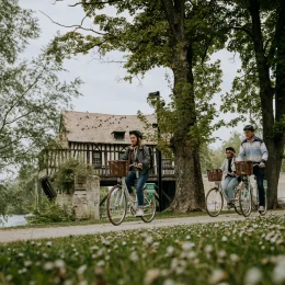 Trois personnes à vélo devant le Vieux Moulin de Vernon
