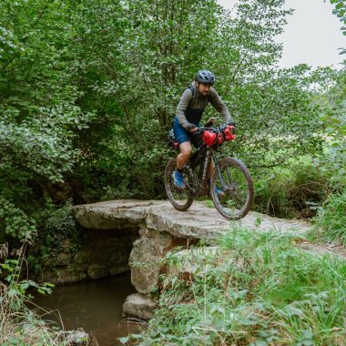 Un homme en VTT sur un pont en pierre sur l'itinéraire de la Normand’Epik VTT