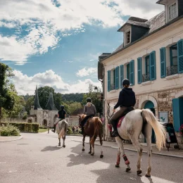 3 personnes à cheval dans les rues du Bec Hellouin