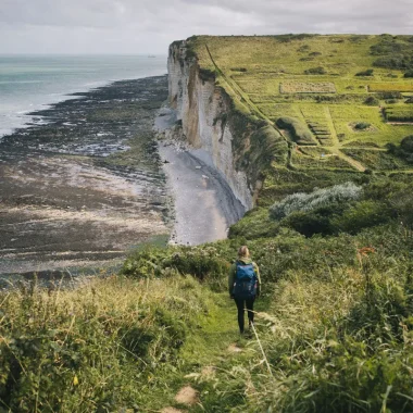 Femme en randonnée sur le GR21 entre Étretat et Yport, vue sur les falaises
